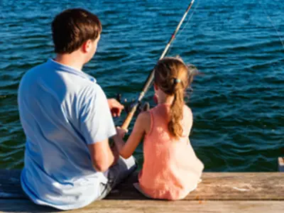 father and daughter fishing off dock