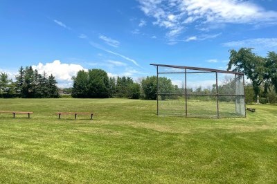 ball field in a park with grass and trees
