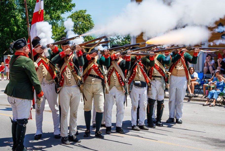 re-enactors firing muskets in bath canada day parade