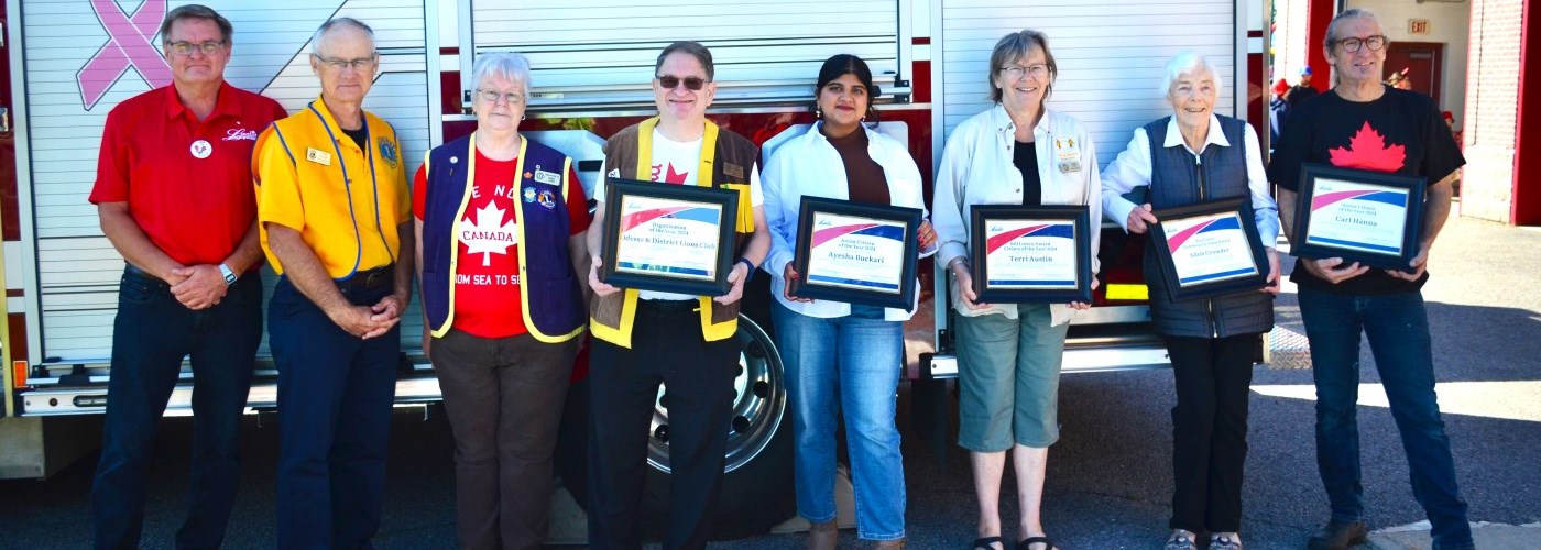 group of men and women holding award certificates