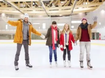 four adults skating at a rink